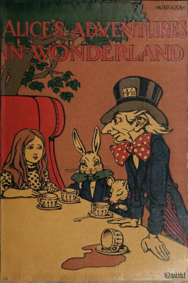 A red cloth cover of Alice’s Adventures in Wonderland showing Alice at the tea table with the Hatter, the March Hare, and the Dormouse
